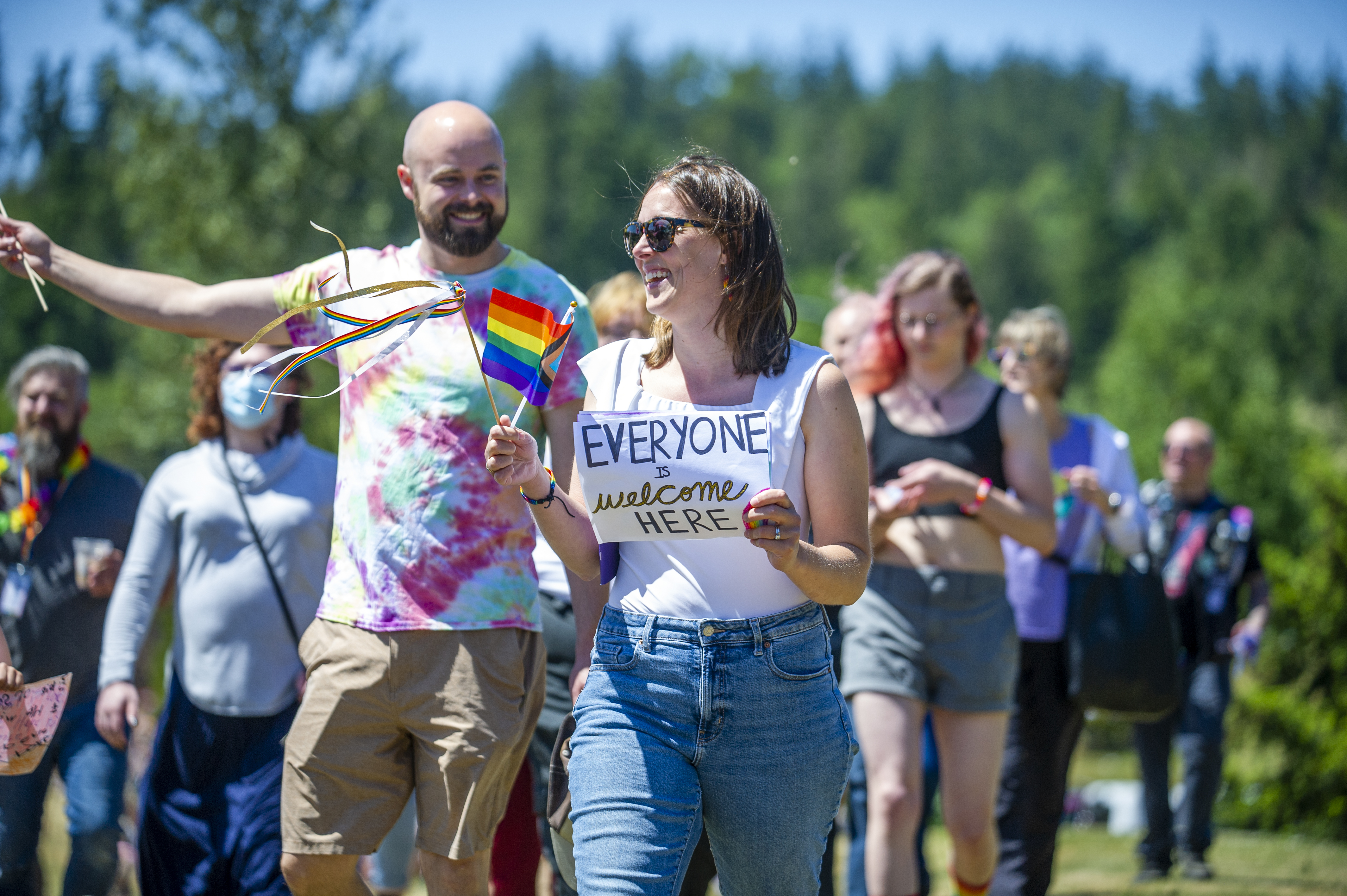 Community members celebrating Pride with rainbow flags